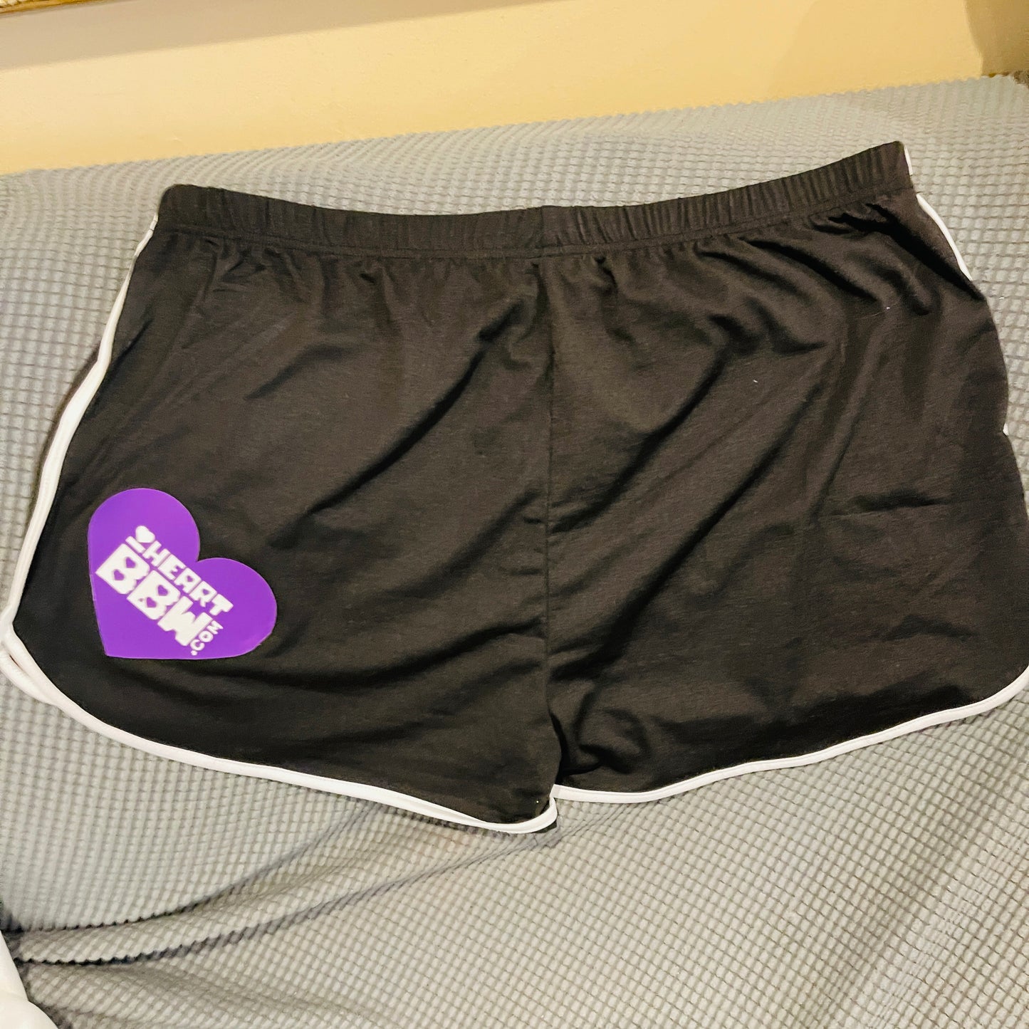 Black sporty shorts with purple/white logo